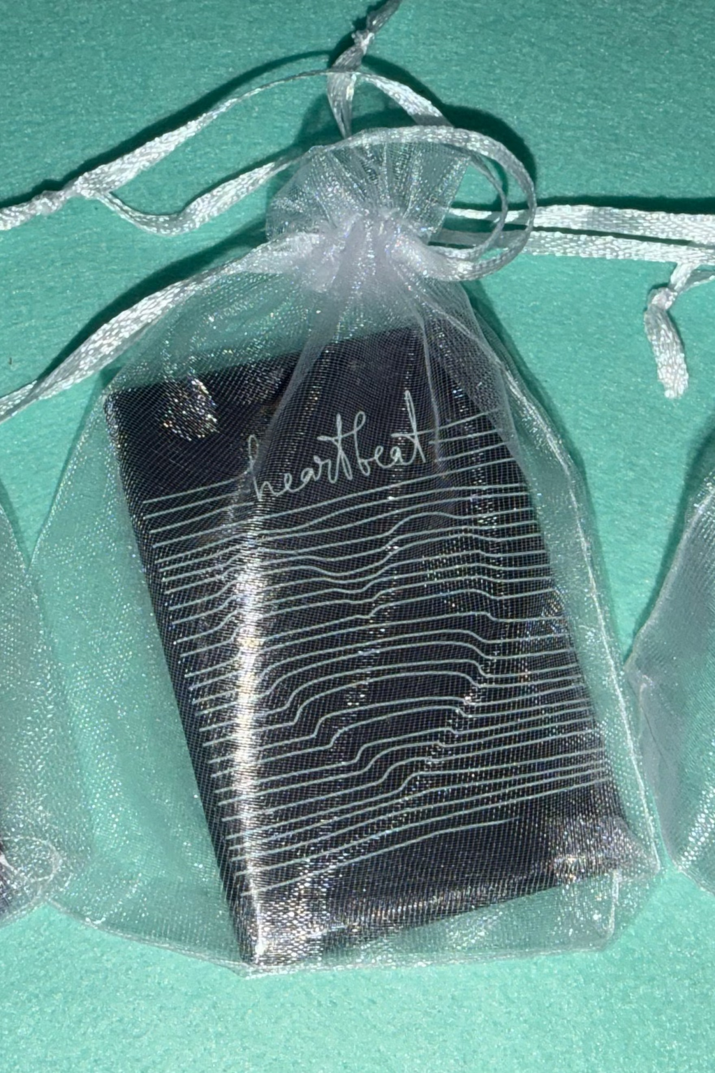  Small decorative bag, magnets inside with text and graphics on a black surface